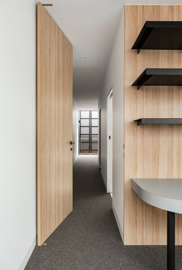 Moderner Flur mit Holzverkleidung, offenen Regalen und minimalistischem Innenausbau.